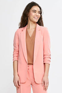 Veste et pantalon coordonnés élégants pour femme en rose saumon, style professionnel et moderne, coupe ajustée, matières confortables, occasions multiples