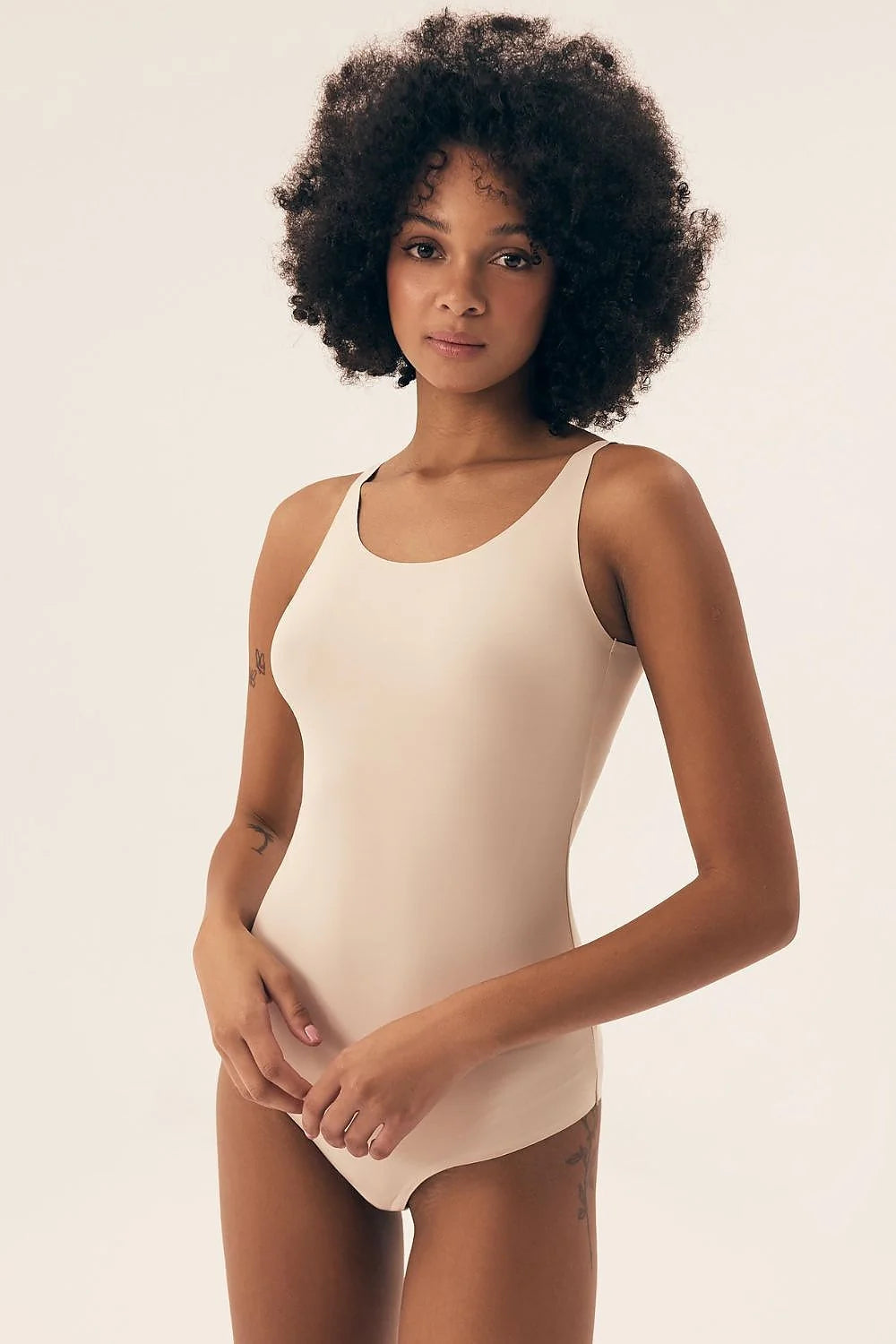 Body minimaliste moderne pour femmes en tissu doux extensible, couleur nude, ajusté, sans armatures, bretelles larges, encolure arrondie, sans fermeture visible, confort maximal, polyvalent, lingerie basique, jours/nuit, style épuré