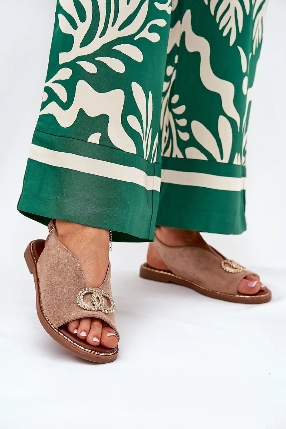 Sandales en daim écofriendly pour femme, style asymétrique, talon plat, sangle réglable, ornement métallique, beige taupe, pantalon floral, tenue élégante, occasion décontractée