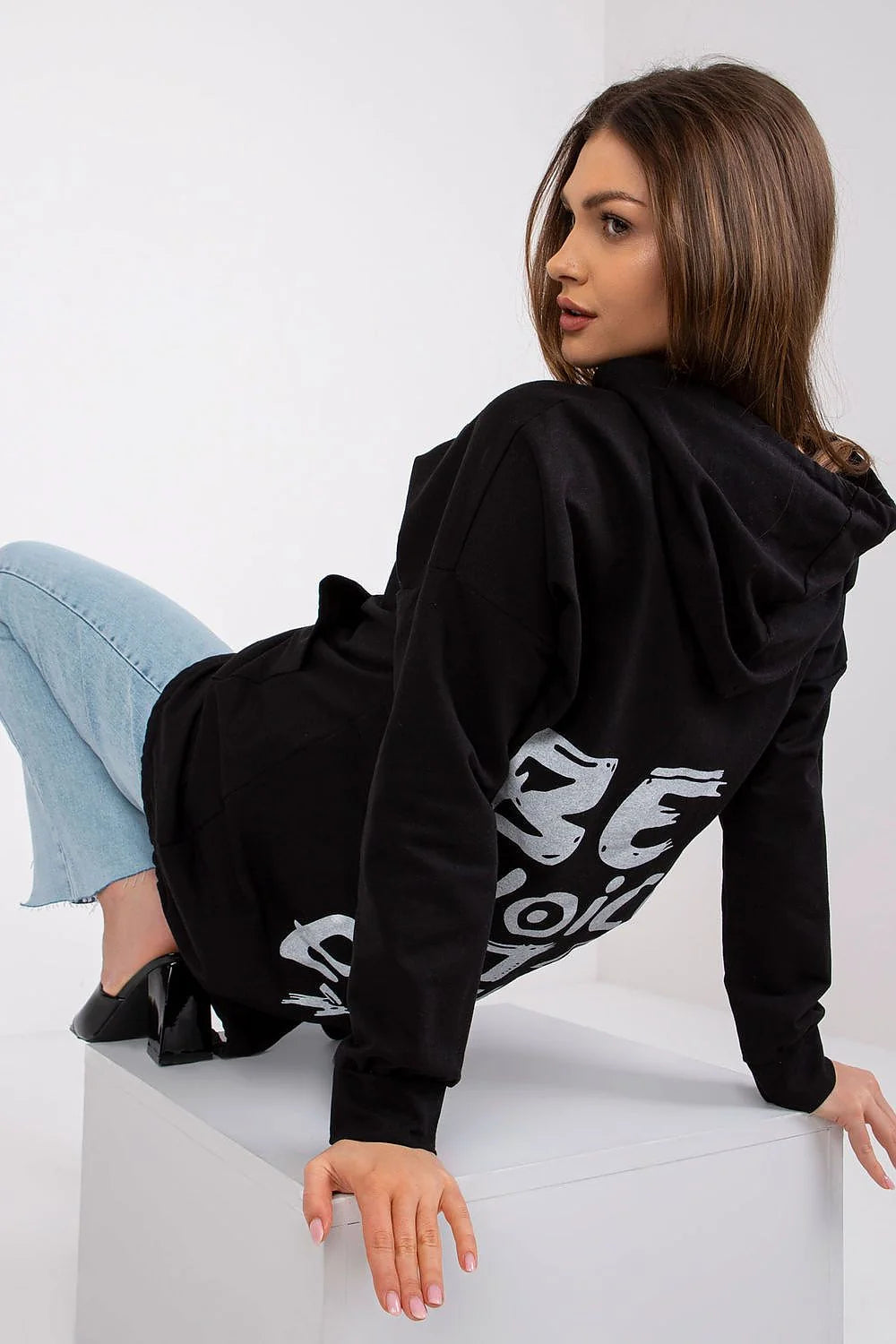Sweatshirt à capuche noir long style décontracté pour femmes avec jeans bleu clair et sandales noires talons hauts mode casual