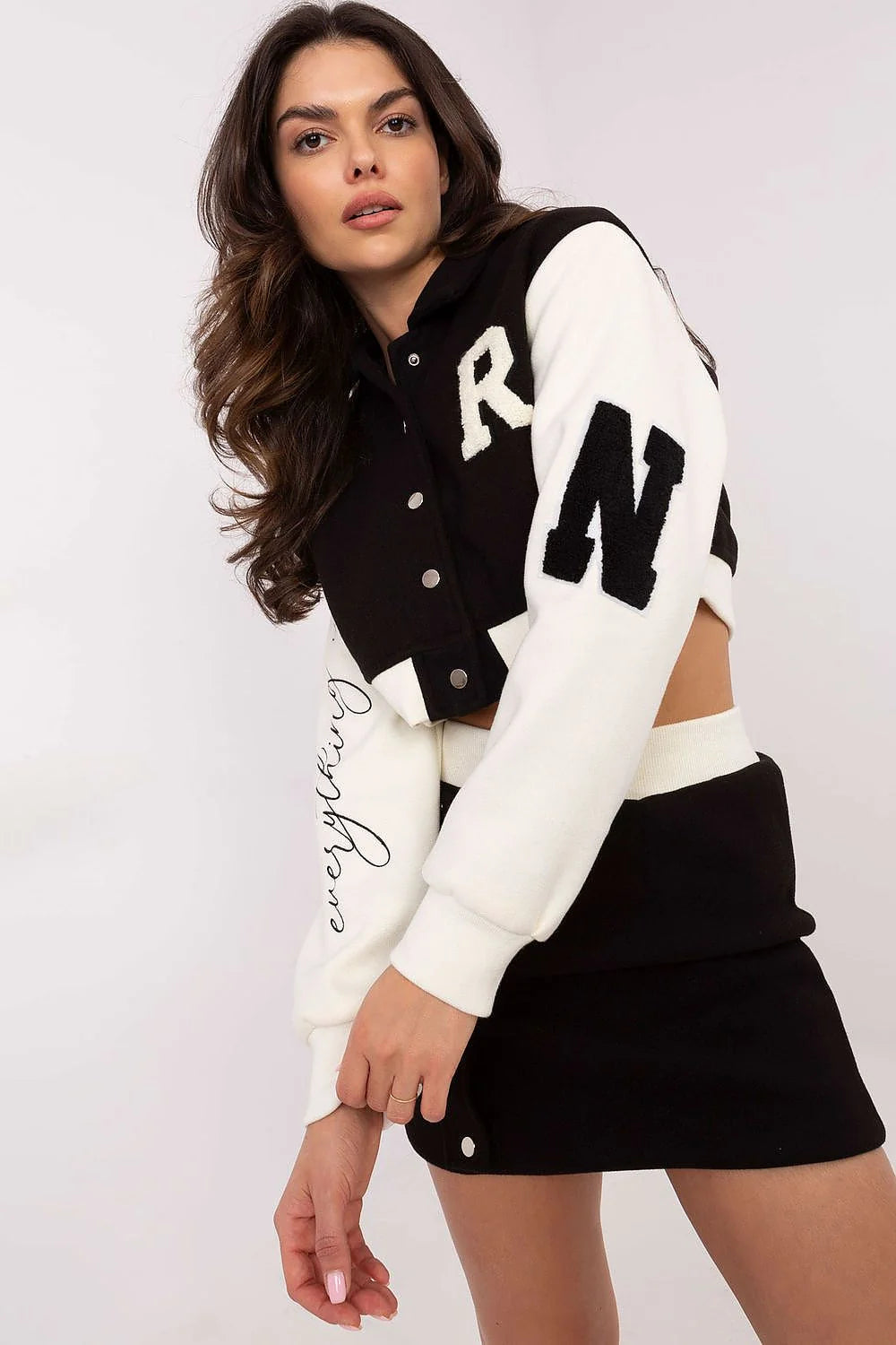 Ensemble féminin style sport-chic veste cropped bomber jupe mini noir blanc manches blanches boutons-pression