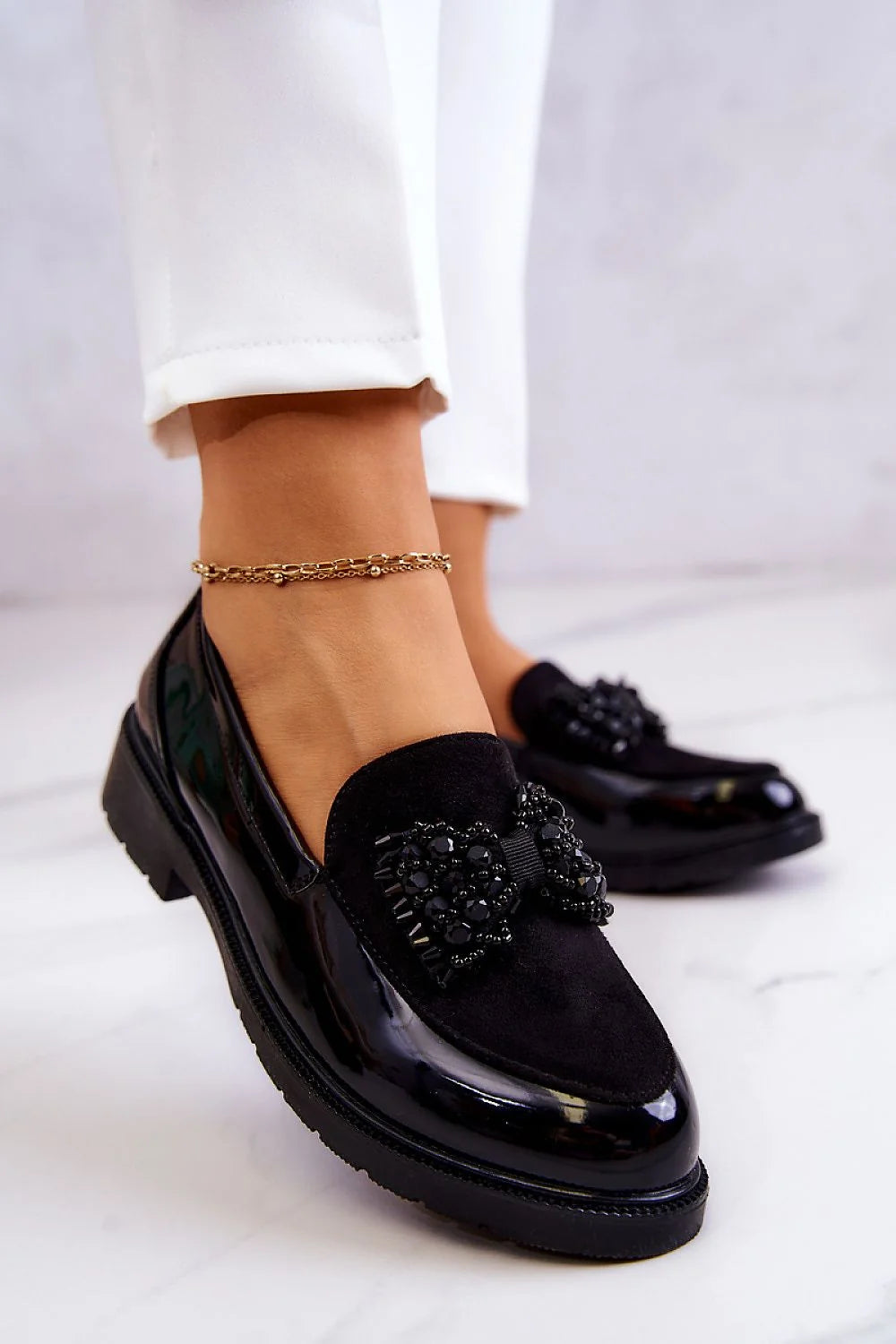 Mocassins élégants modernes pour femmes cuir écologique suède texture contraste nœud perles cristaux noir blanc pantalon sac bracelet