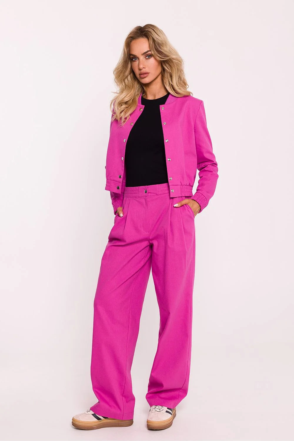 Veste bomber moderne pour femme en tissu coton vibrant rose fuchsia, manches élastiquées, boutons-pression métalliques, coupe ajustée, col côtelé, sans doublure, pantalon high-waisted assorti, look casual ou semi-formel