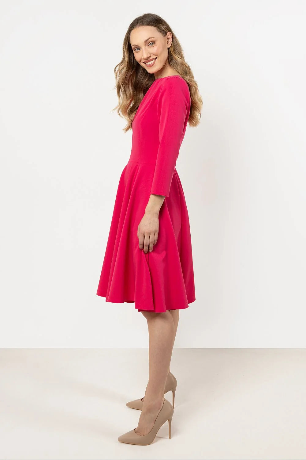 robe élégante fuchsia manches trois quarts col rond coupe ajustée taille marquée jupe évasée plis tissu structuré confortable