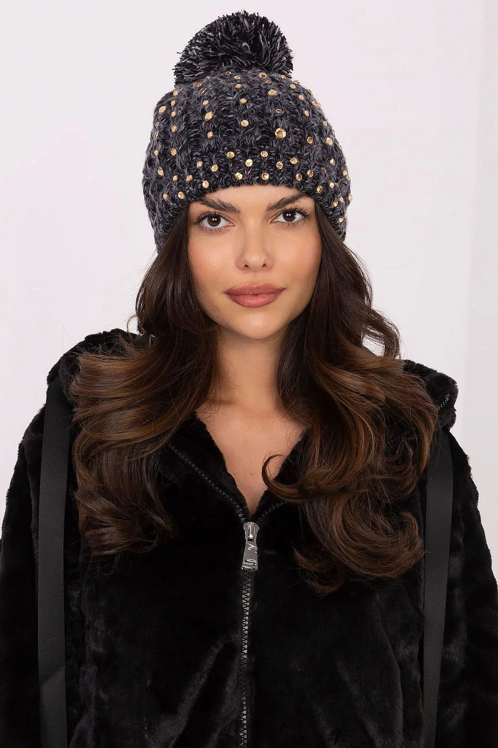 Bonnet de mode élégant pour femmes en matière tricotée épaisse couleur gris foncé avec strass dorés et pompon moelleux ajustement élastique finitions précises style chic et contemporain pour hiver