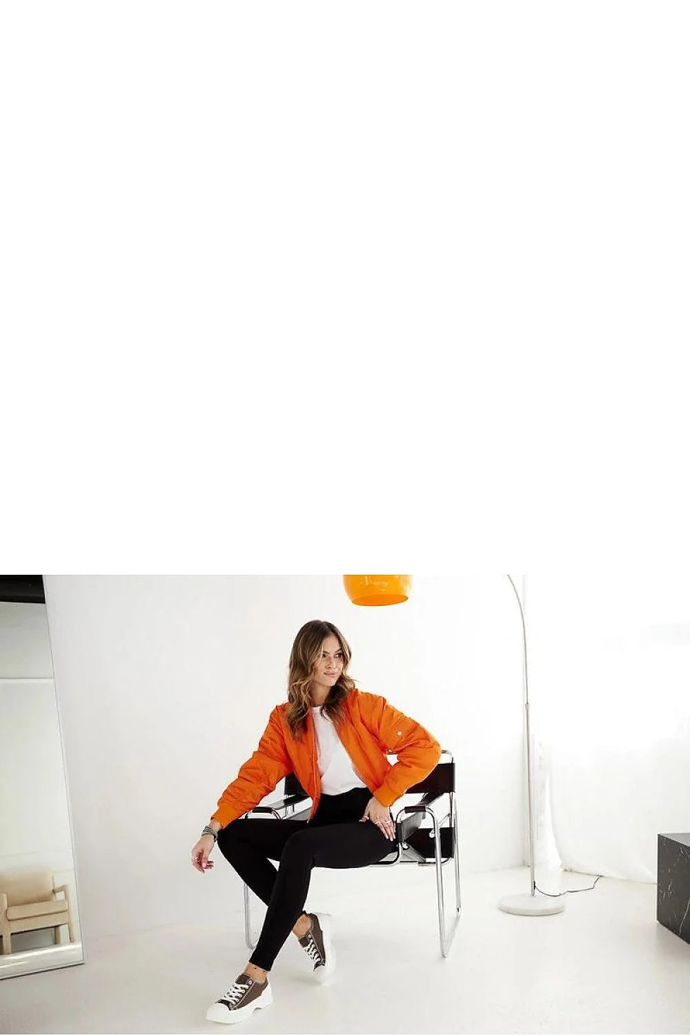 Tenue décontractée moderne pour femmes veste bomber orange t-shirt blanc pantalon noir baskets sneakers style urbain