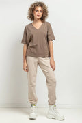 Haut et pantalon femme style casual modern utilitaire couleur neutre matelassé coton élastique porté avec bottines blanches
