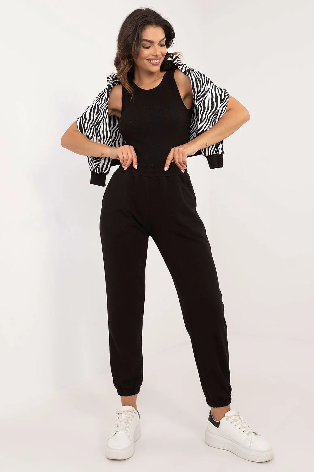 Ensemble femme style décontracté pull zébré noir et blanc pantalon noir taille élastique baskets blanches