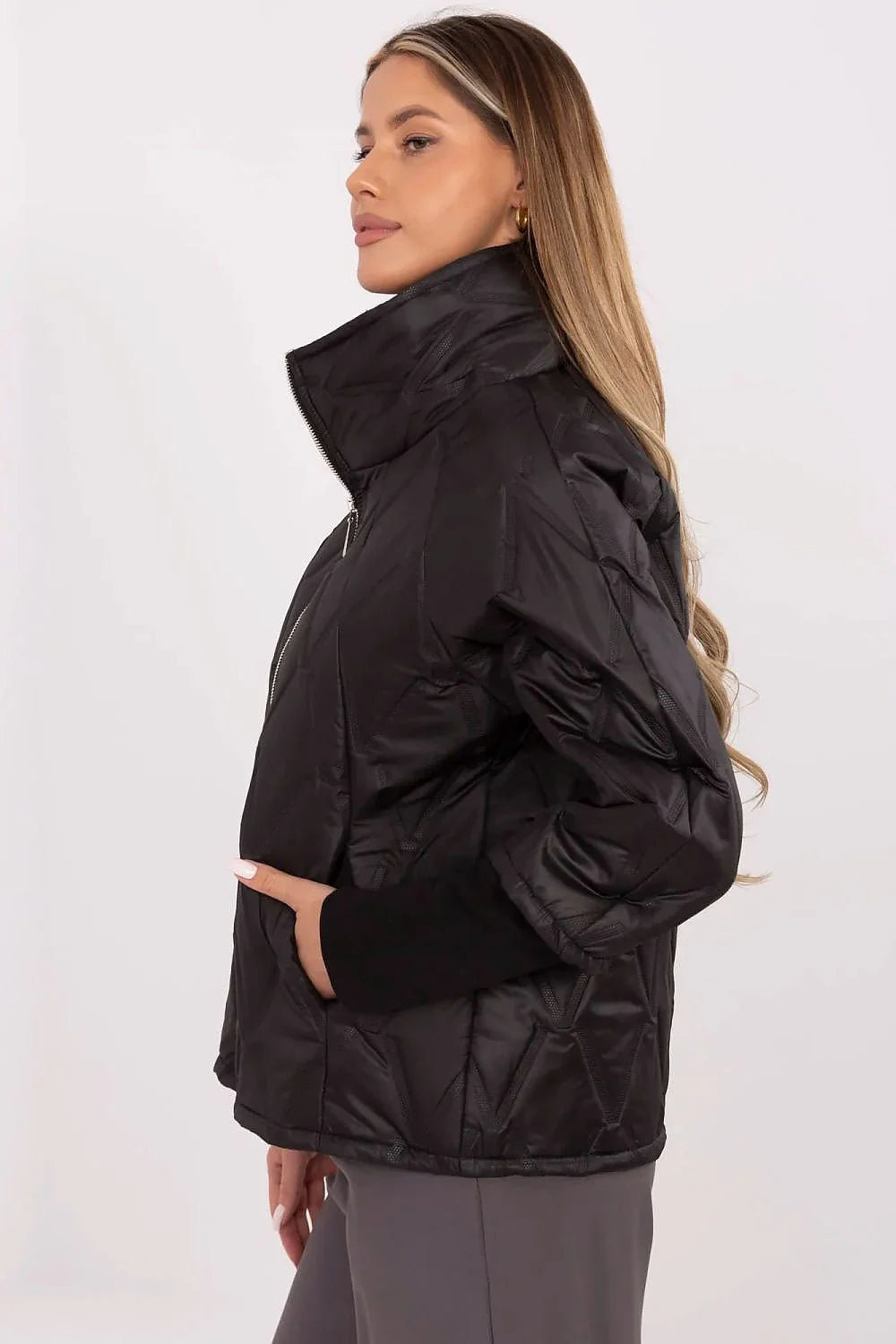Veste courte femme design moderne épuré couleur noire tissu synthétique brillant motifs géométriques relief col montant fermeture éclair métallique poches latérales manches 3/4