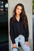 Chemise femme manches longues asymétrique Oversize noir tissu léger coupe moderne boutons poignets poche poitrine détails élégants