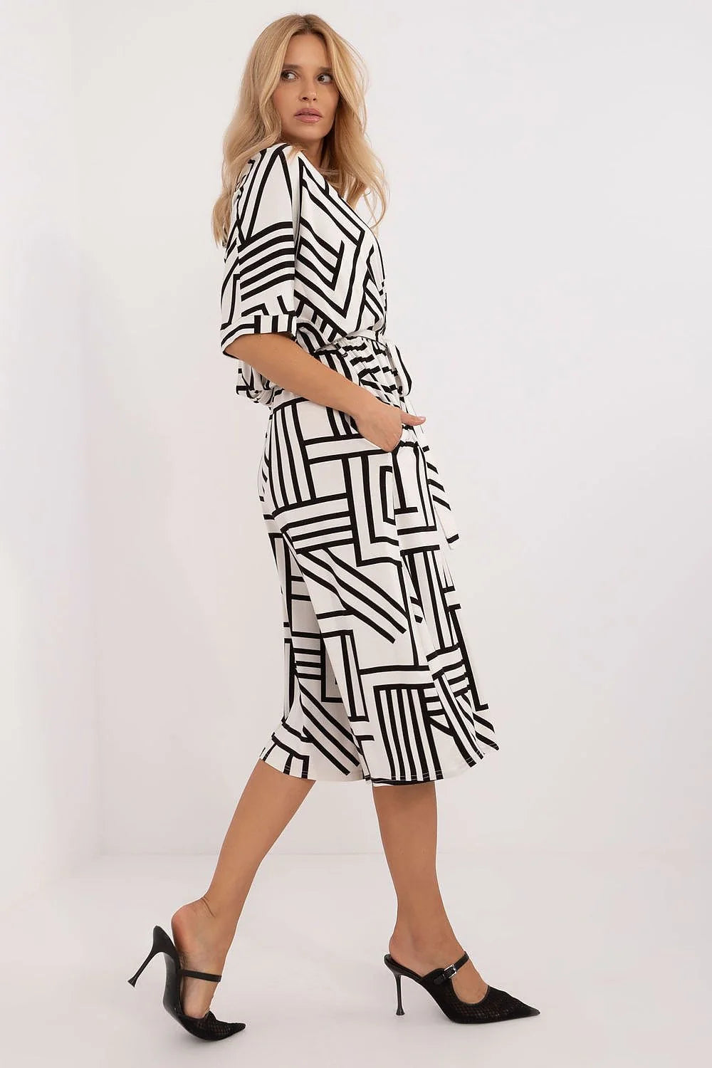 Robe féminine design moderne graphique motif géométrique couleurs contrastantes coupe midi ceinture ajustable manches trois quarts poches latérales vêtement versatile occasion formelle décontractée