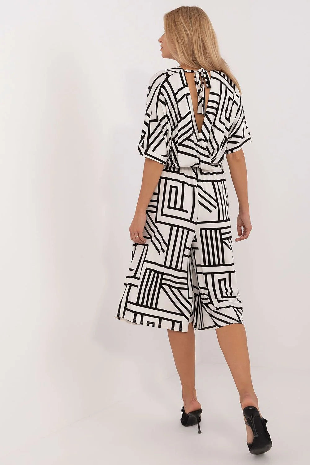 Robe féminine design moderne graphique motif géométrique couleurs contrastantes coupe midi ceinture ajustable manches trois quarts poches latérales vêtement versatile occasion formelle décontractée