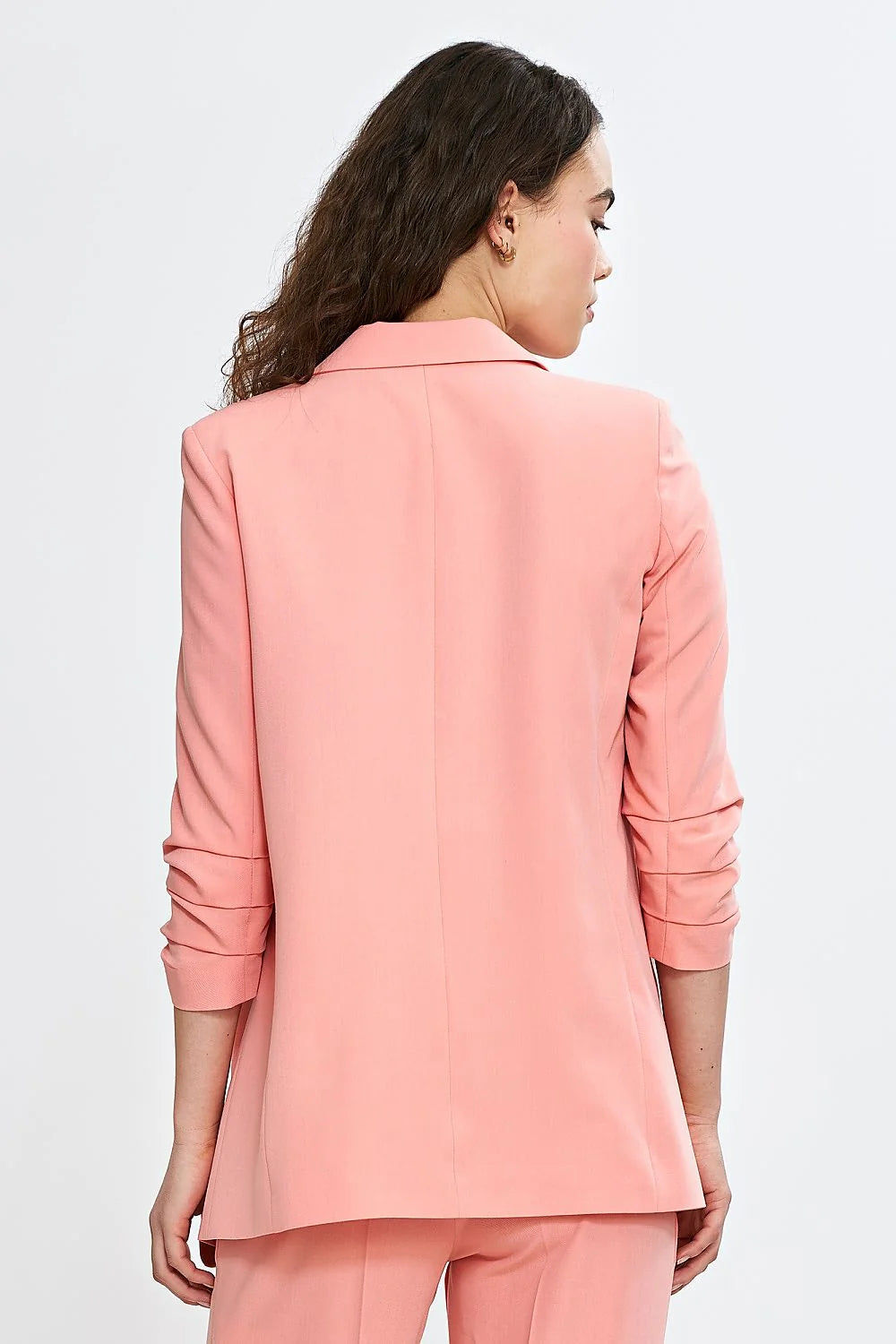 Veste et pantalon coordonnés élégants pour femme en rose saumon, style professionnel et moderne, coupe ajustée, matières confortables, occasions multiples