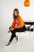 Tenue décontractée moderne pour femmes veste bomber orange t-shirt blanc pantalon noir baskets sneakers style urbain