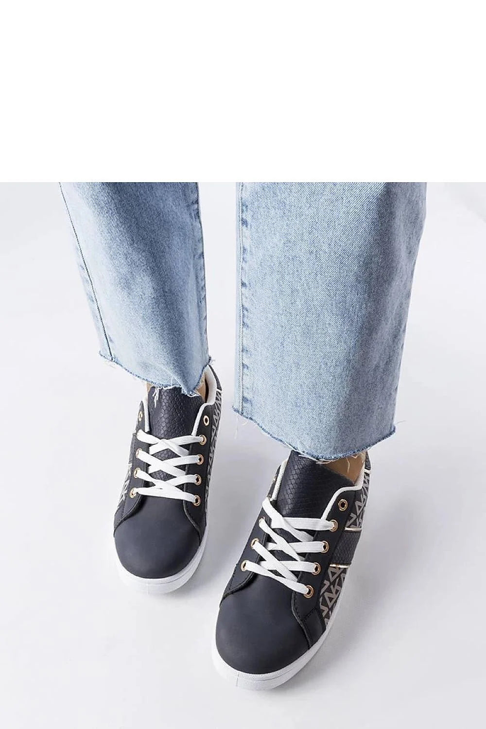 Sneakers femme design moderne élégant cuir synthétique noir motifs géométriques beige tige basse lacets blancs œillets dorés semelle épaisse caoutchouc confort style casual