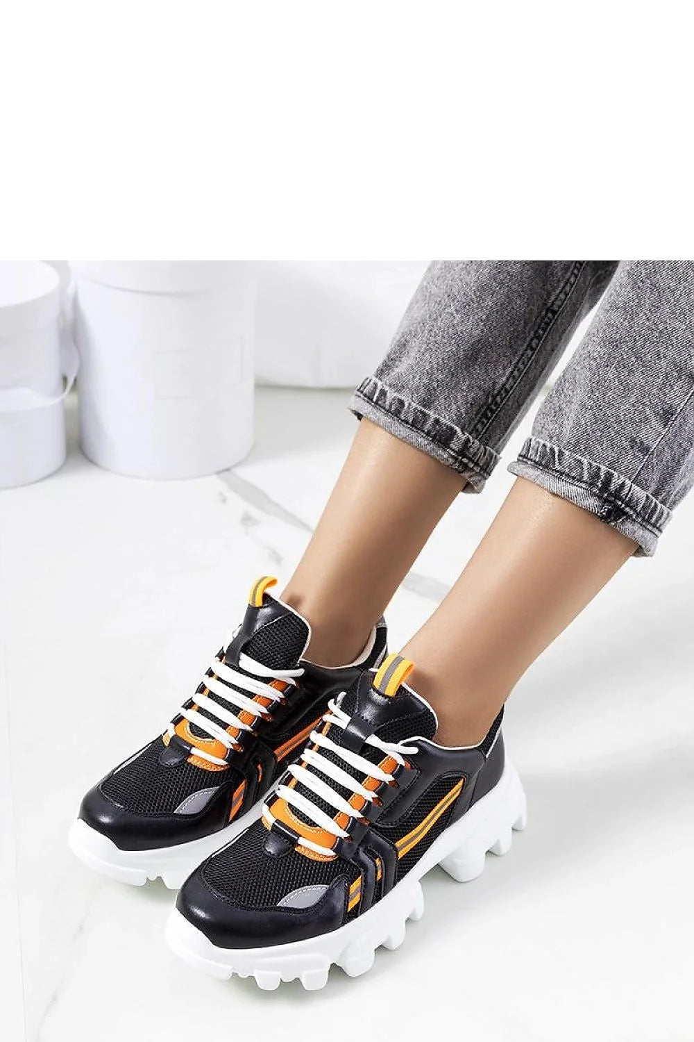 Baskets sportives modernes pour femmes en cuir synthétique et mesh noir, accents orange, semelle épaisse blanche, style chunky, confortable et élégante