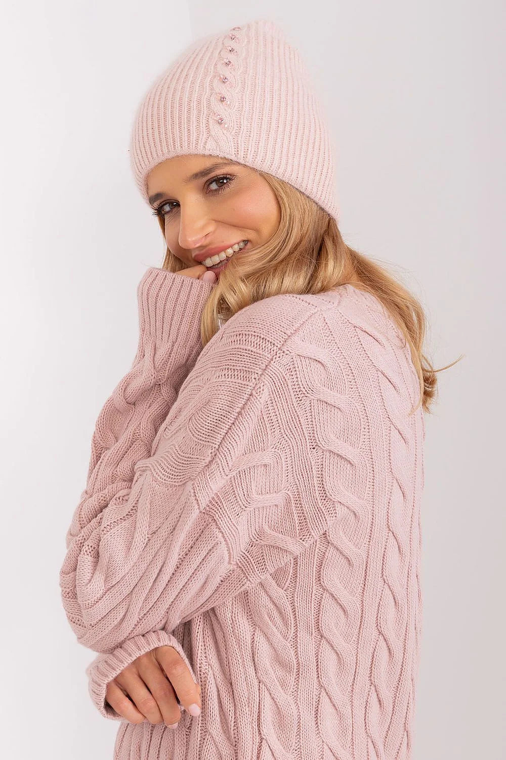Ensemble hiver féminin bonnet pull maille torsadée rose pâle matières chaudes style moderne élégant
