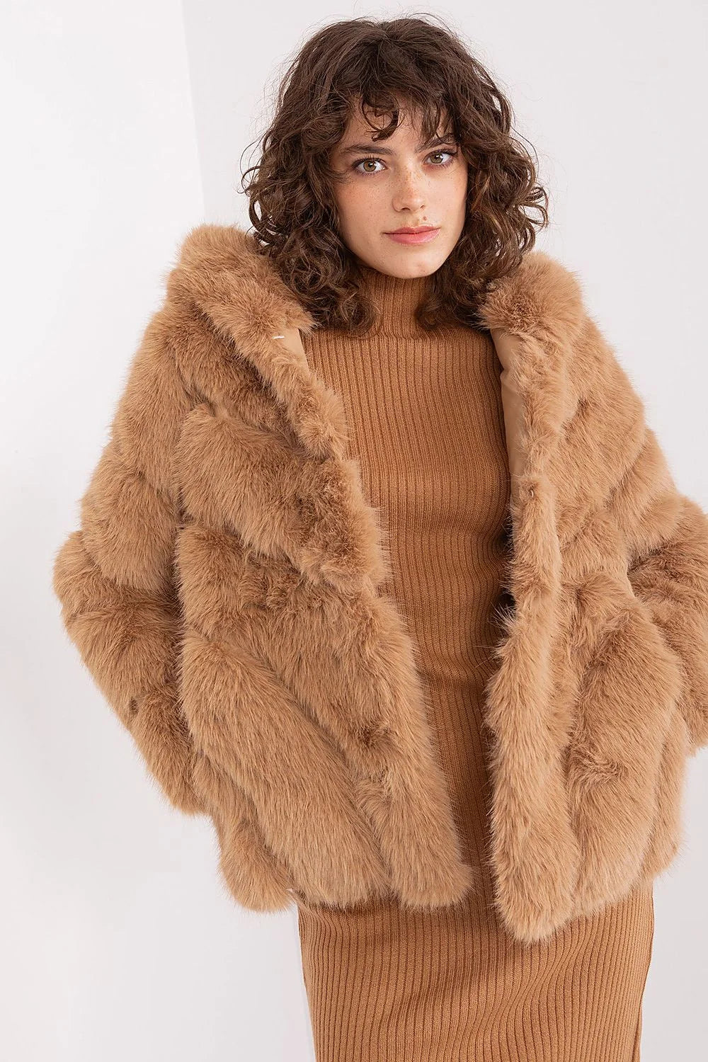 Manteau en fausse fourrure couleur camel design volumineux capuche robe tricotée bottes cuir synthétique style moderne chaleureux femme