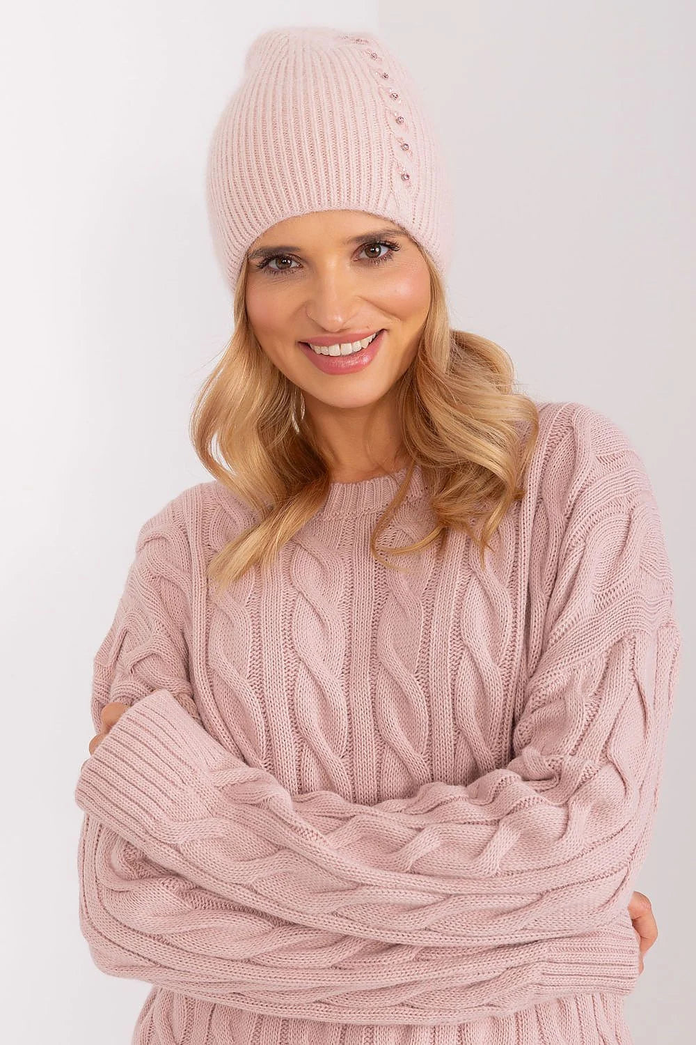 Ensemble hiver féminin bonnet pull maille torsadée rose pâle matières chaudes style moderne élégant