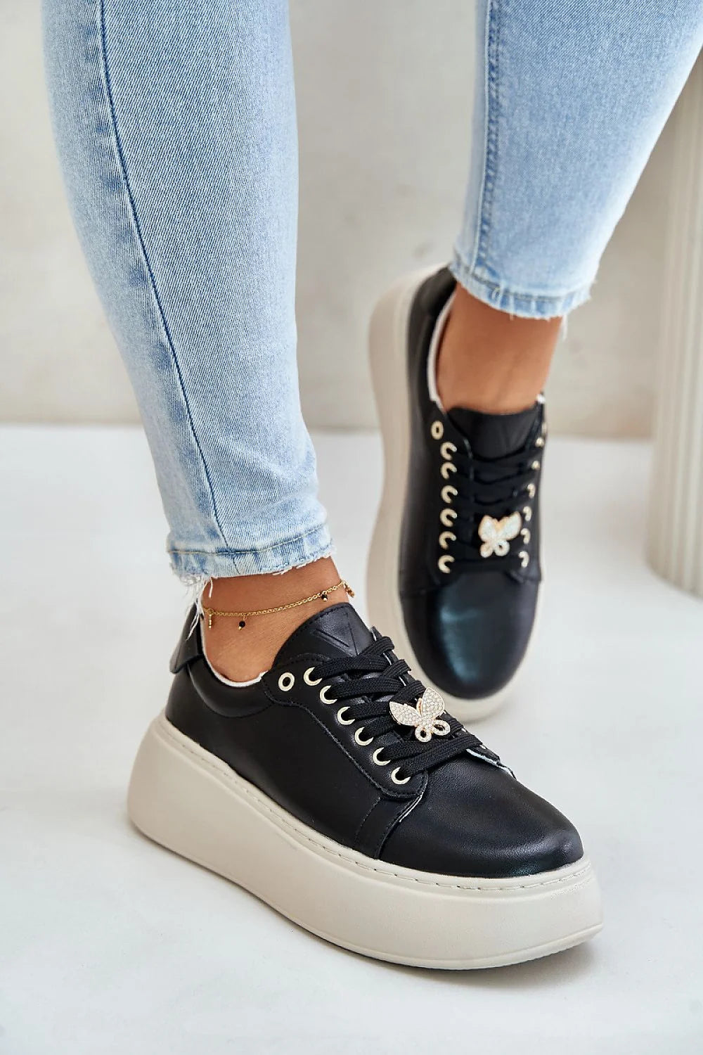 baskets femme similicuir noir plateforme compensées semelle épaisse blanche contrastée bout rond lacets œillets dorés breloque papillon strassée