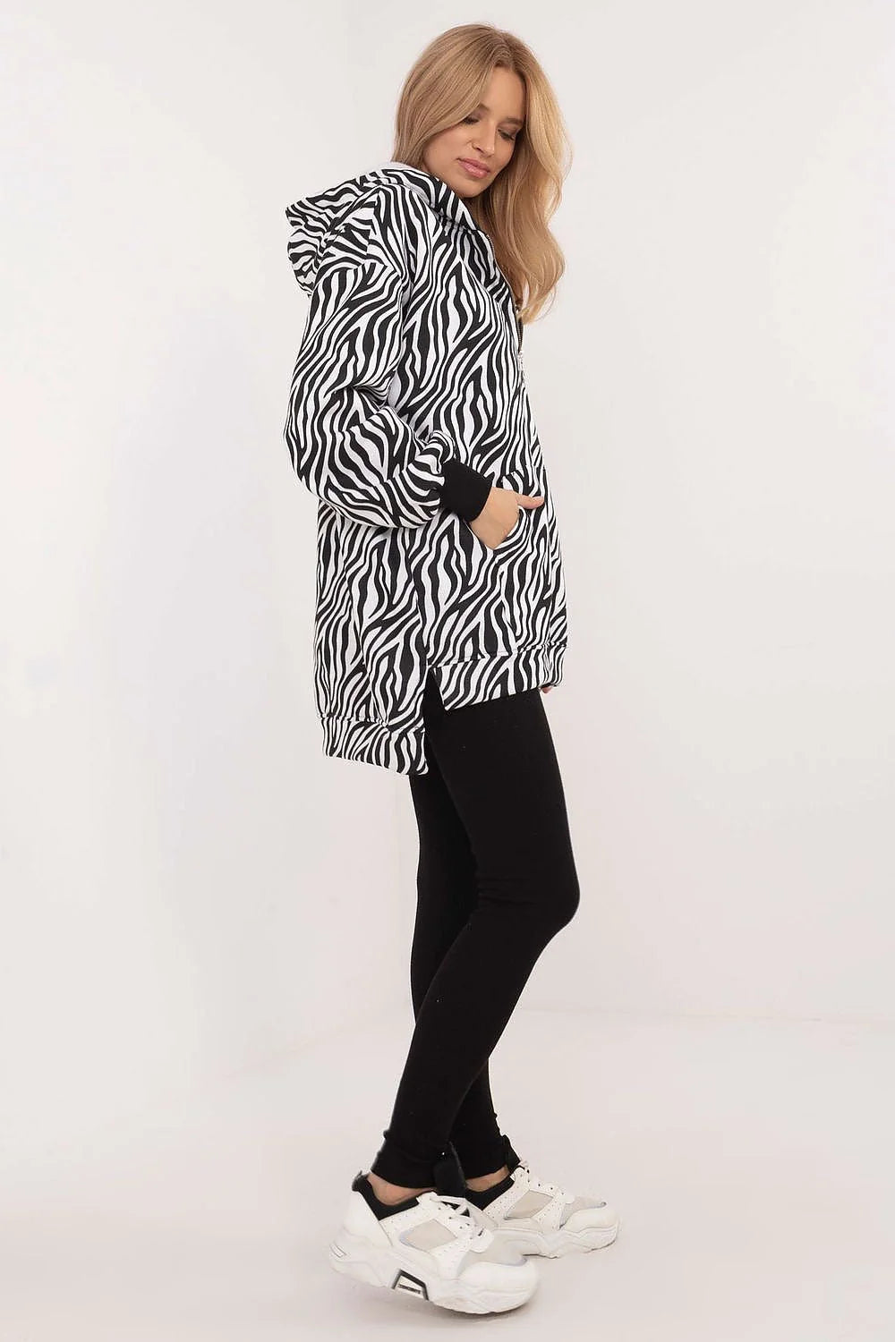 Veste zébrée audacieuse avec leggings noirs et sneakers blanches mode femme confortable