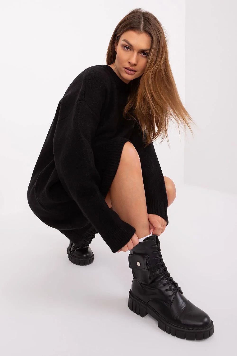 Robe pull Badu en tricot longues manches col rond noir associée à des bottines militaires femmes