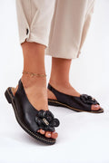 Sandales élégantes pour femmes en cuir noir, slingback, fleur décorative, semelle cloutée dorée, talon plat, style chic et confortable