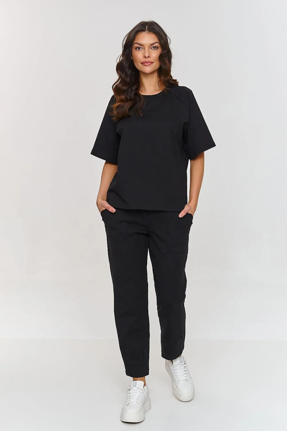 Confortable ensemble de survêtement pour femme en coton noir, coupe ample et droite, manches courtes, poches latérales, style casual, idéal pour quotidien et loisirs actifs