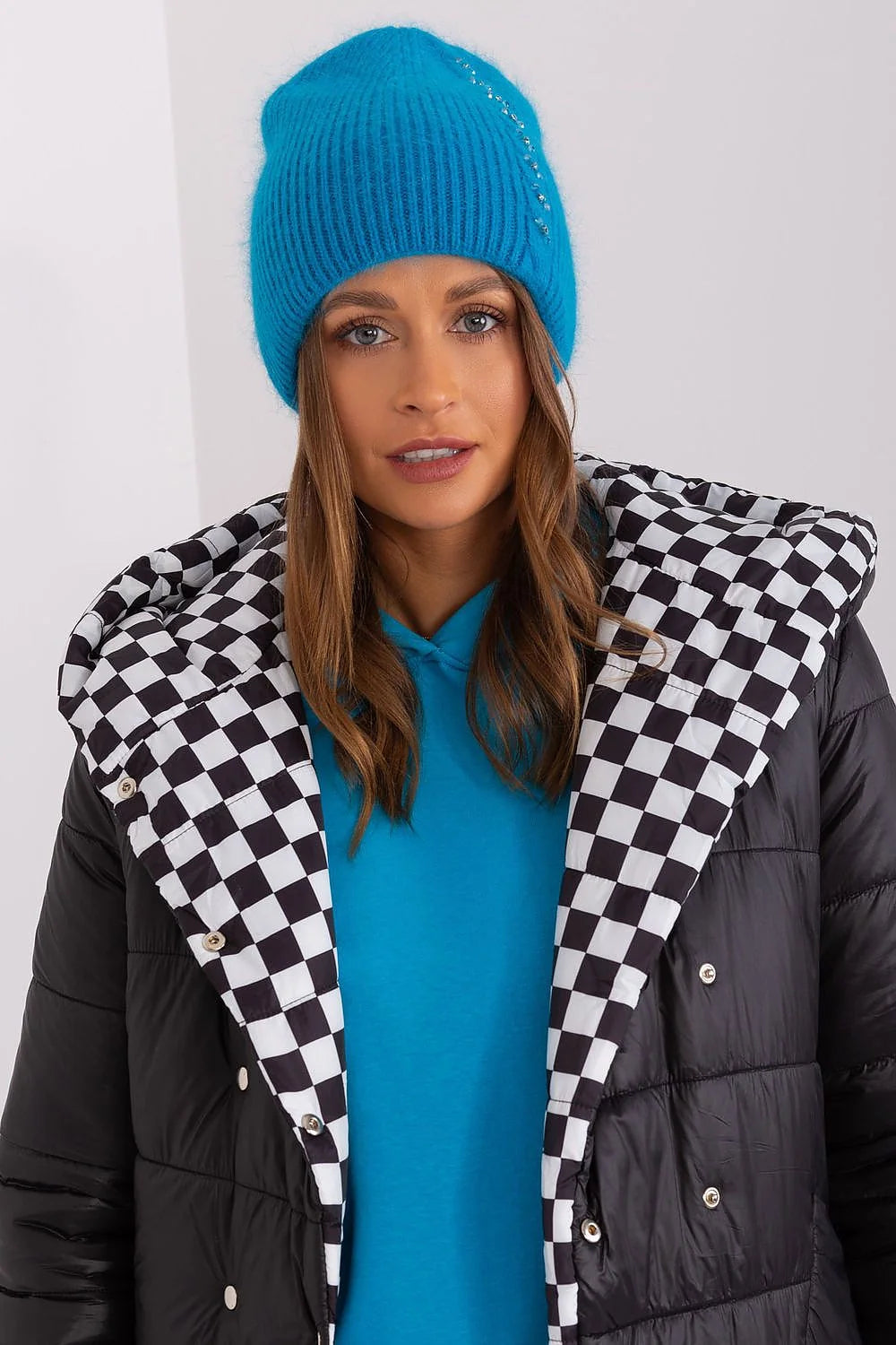 Bonnet d'hiver féminin en maille texture côtelée bleu vif éléments scintillants veste matelassée noire sweat-shirt bleu style moderne