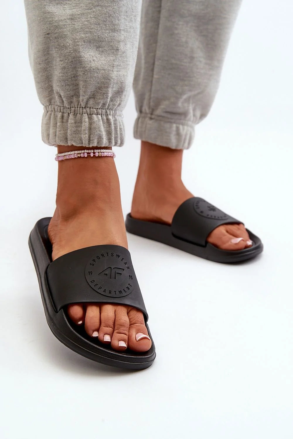 claquettes femmes noires slides bride large embossée logo rond semelle épaisse ergonomique moulée amorti confort EVA antidérapante minimaliste sportive