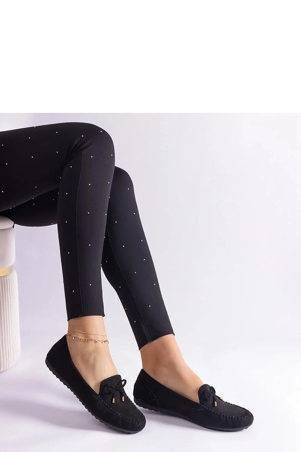 Tenue élégante pour femme pantalon slim ajusté et mocassins noirs en cuir avec détails métalliques et motifs strass