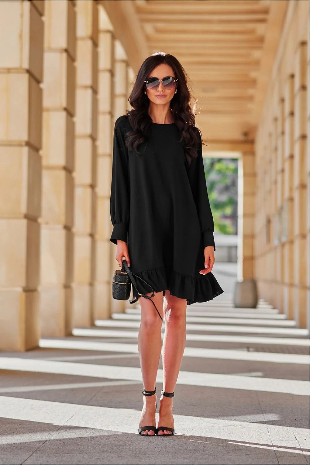 robe noire élégante courte fluide trapèze manches longues poignets froncés cintrée taille ceinturée boucle dorée volants polyvalente chic sophistiquée