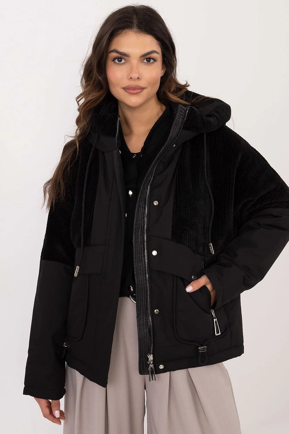 Veste urbaine moderne pour femme en polyester noir avec capuche fixe, poches zippées, finitions métalliques et coupe décontractée