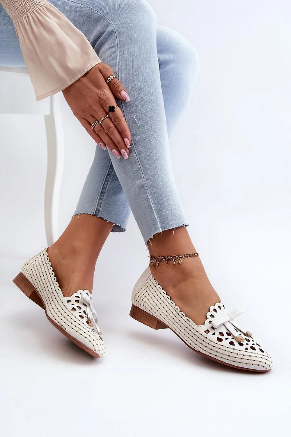 Mocassins femme élégance moderne blanc cassé cuir artificiel perforations géométriques cœur nœud doré embouts métalliques talon bas semelle antidérapante chic