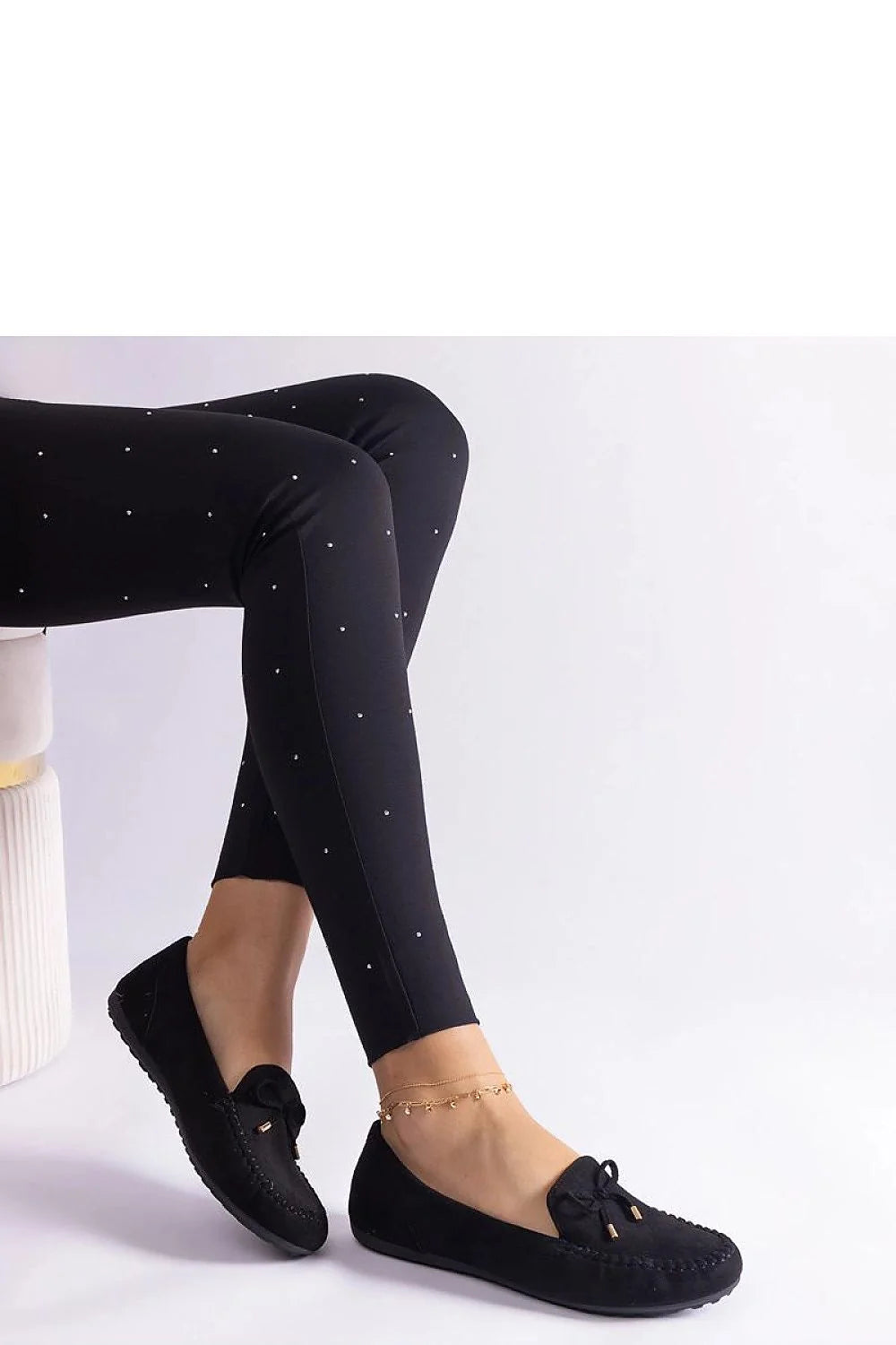 Tenue élégante pour femme pantalon slim ajusté et mocassins noirs en cuir avec détails métalliques et motifs strass