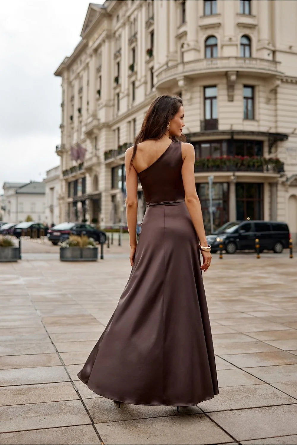 robe longue satinée chocolat soirée élégante asymétrique épaule dévoilée bretelle froncée taille ajustée jupe vaporeuse fente haute boutons dorés