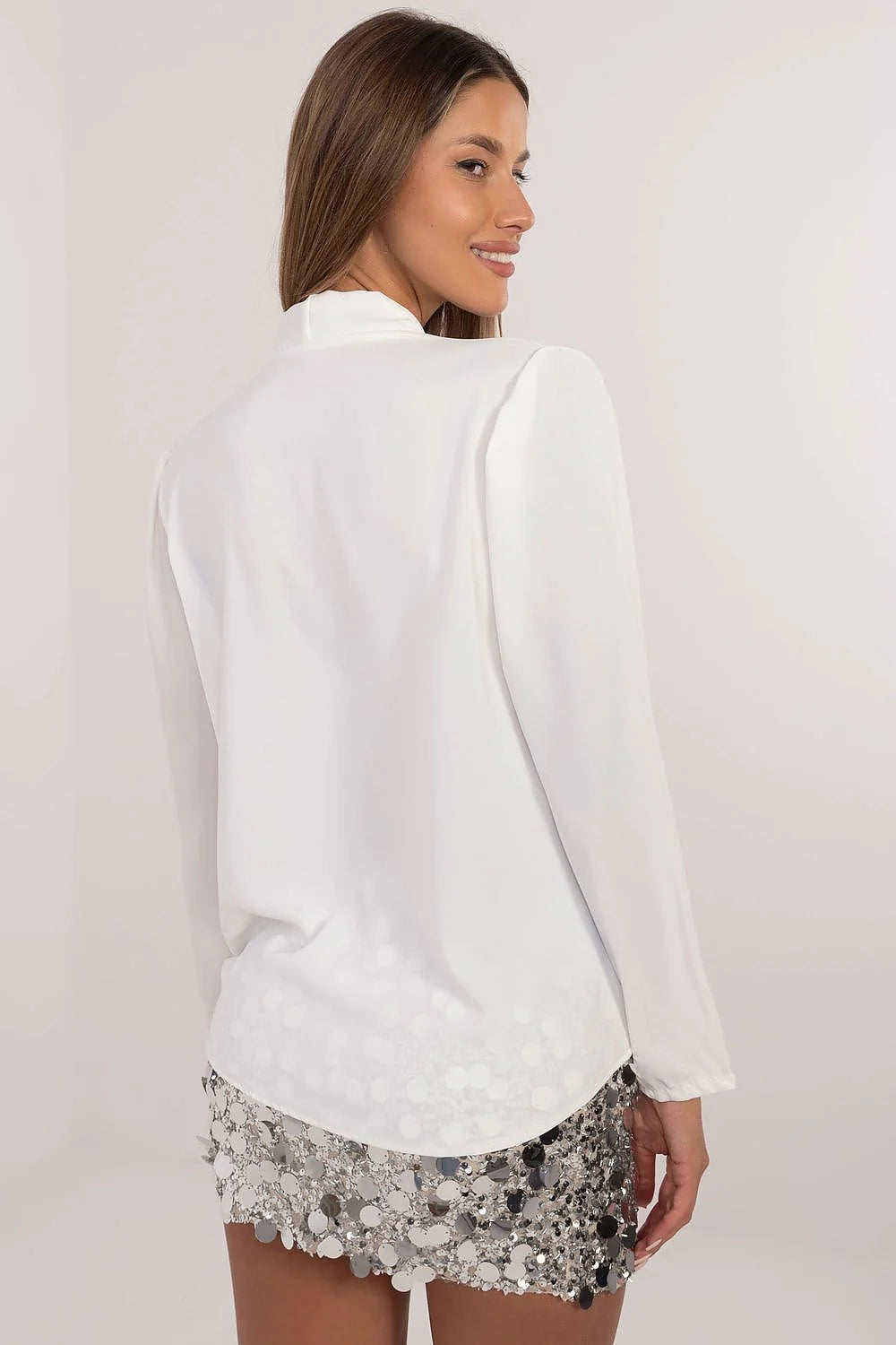 ensemble féminin élégant scintillant haut ivoire cachecoeur manches longues voile drapé satiné fleur oversize jupe courte paillettes argentées ajustée glamour