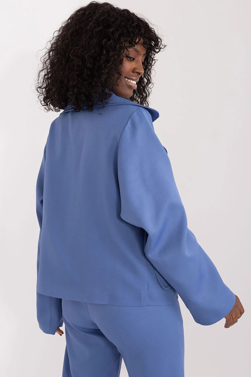 Tailleur féminin complet bleu vif coupe structurée épaules oversized manches longues pantalon large