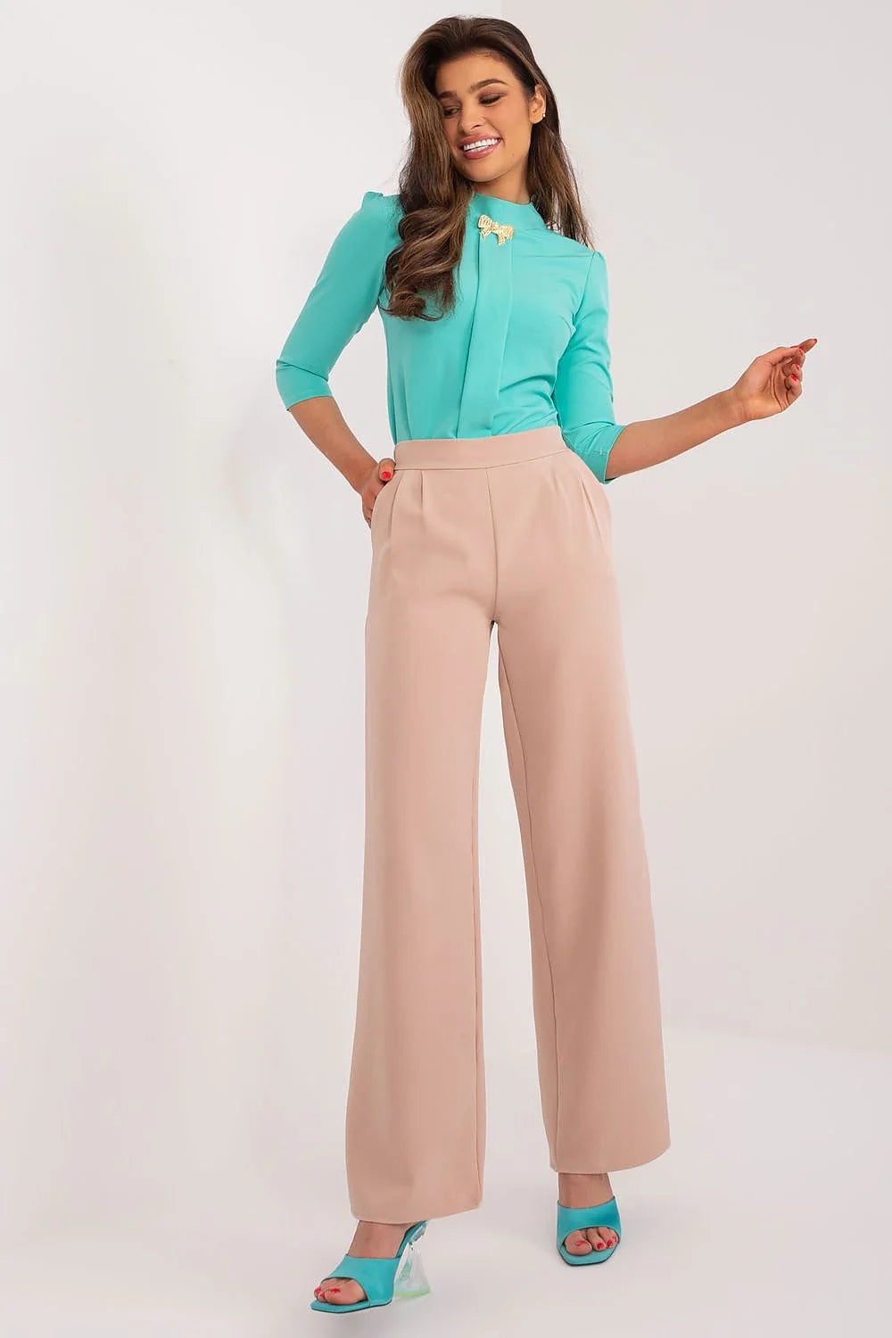 Tenue élégante femme blouse turquoise pantalon beige clair ornement doré coupe ajustée palazzo style moderne