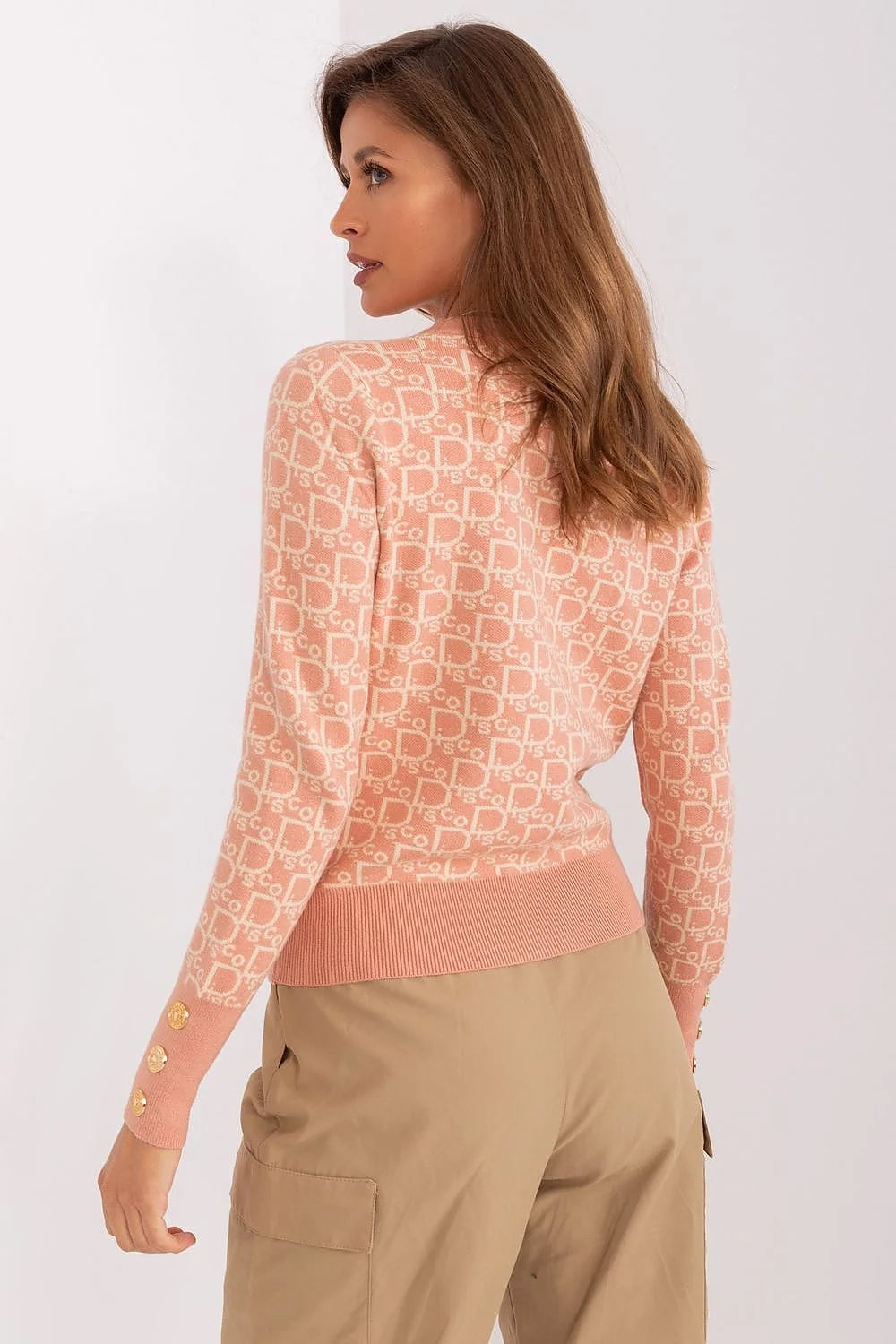 Pullover féminin moderne élégant couleur rose pâle motif géométrique manches longues col rond boutons dorés coupe ajustée textile coton laine