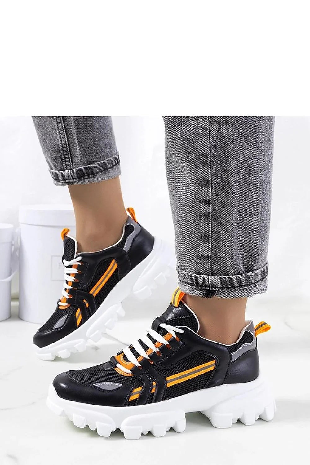 Baskets sportives modernes pour femmes en cuir synthétique et mesh noir, accents orange, semelle épaisse blanche, style chunky, confortable et élégante