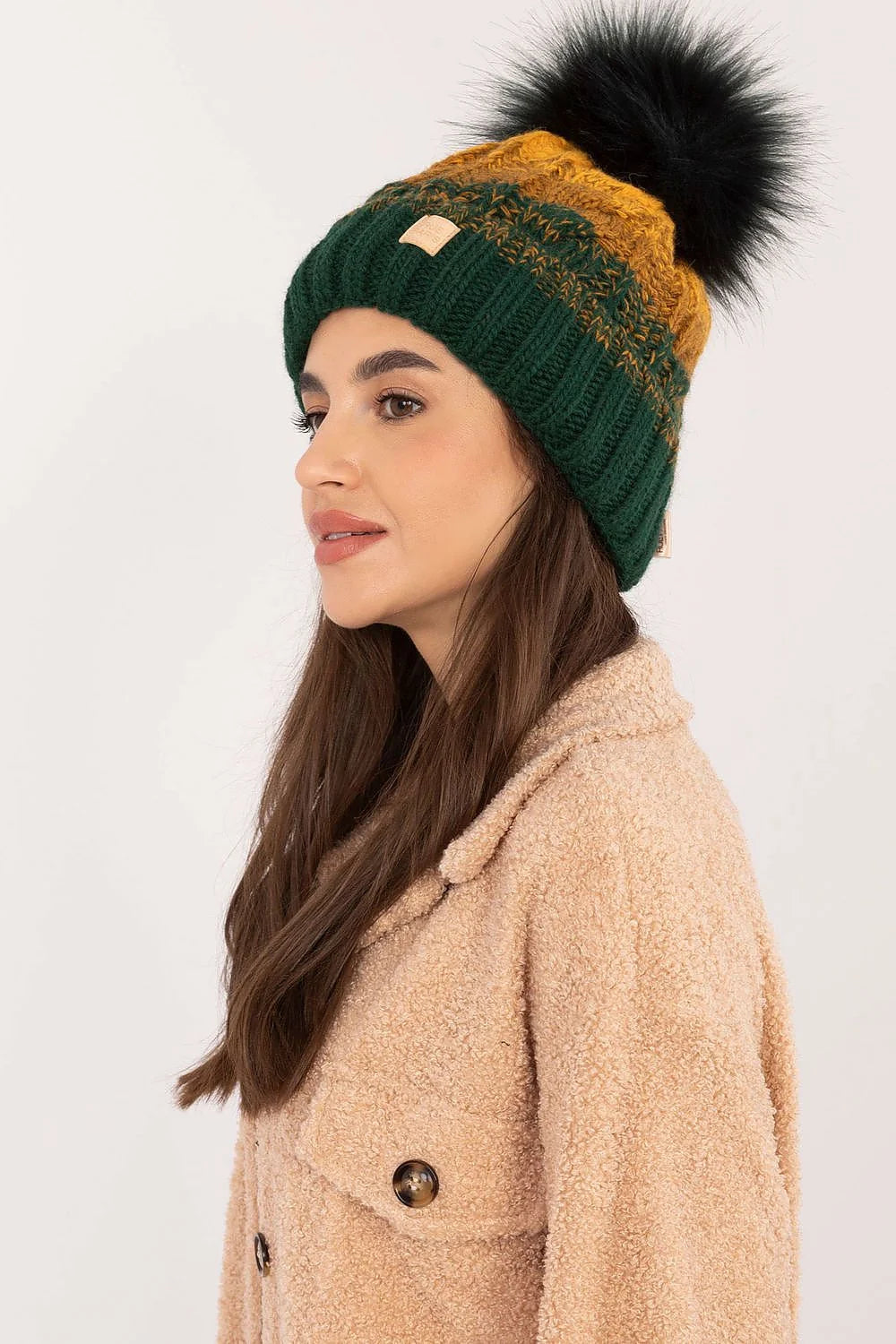 Bonnet tricoté pour femme couleur verte foncée et moutarde, motif écossais, pompon fourrure noire, doublure polaire, style hivernal élégant, coupe classique, matières chaudes et confortables