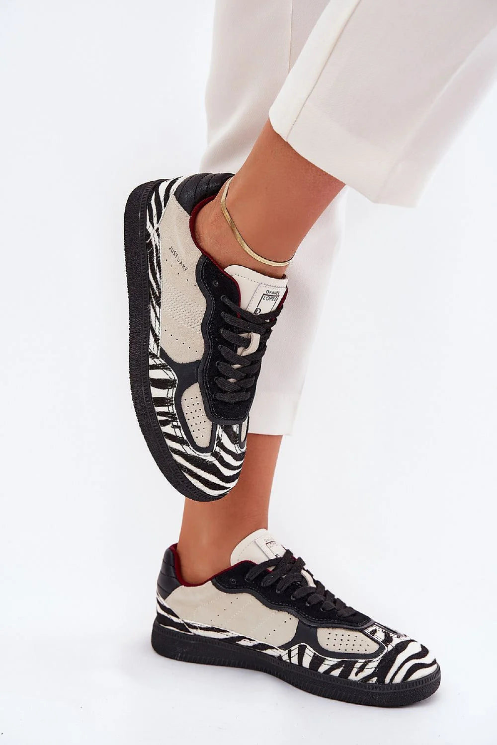 Chaussures de sport design audacieux modernes femme cuir beige perforations motif zébré noir blanc confort semelle caoutchouc robuste