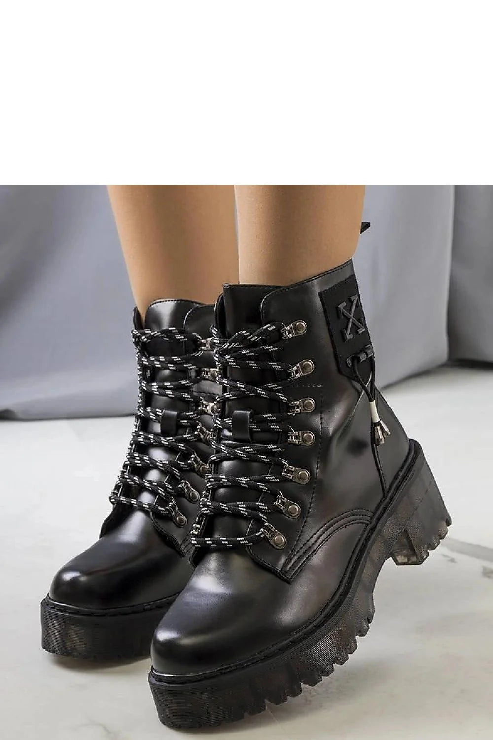 Bottes combat femme style audacieux cuir noir semelle épaisse lacets bicolores métalliques renfort cheville