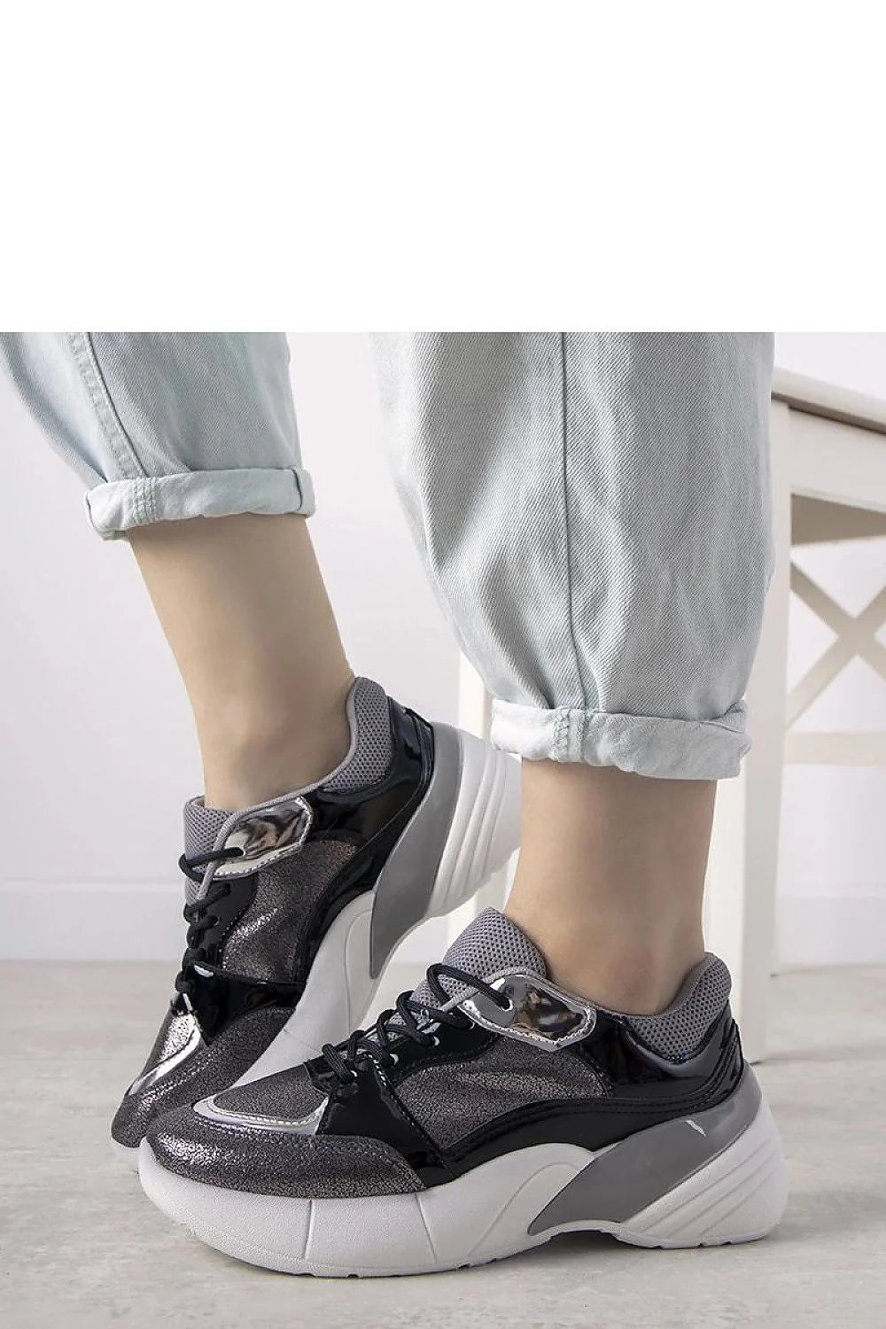 Chaussures de sport femmes design contemporain audacieux matériaux variés textures reflets mesh gris cuir verni noir accents métalliques semelle épaisse blanche volumineuse tendance
