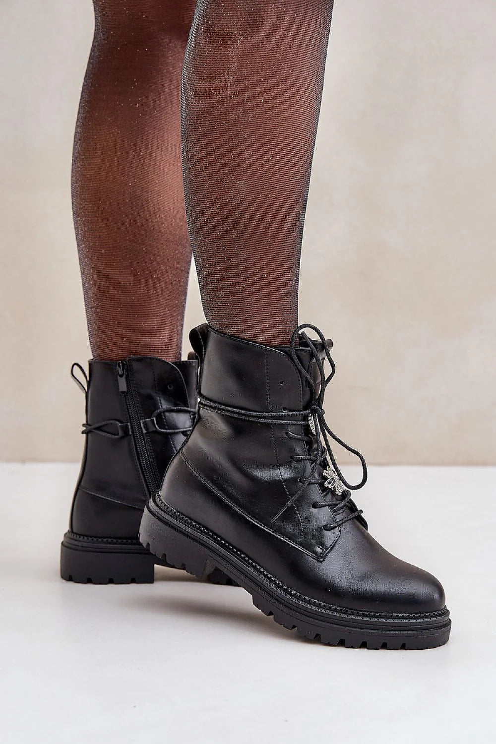 bottines cuir écologique noir bout arrondi lacets pendentif métallique zip latéral broches doublure fourrure synthétique semelle crantée antidérapante talons plats