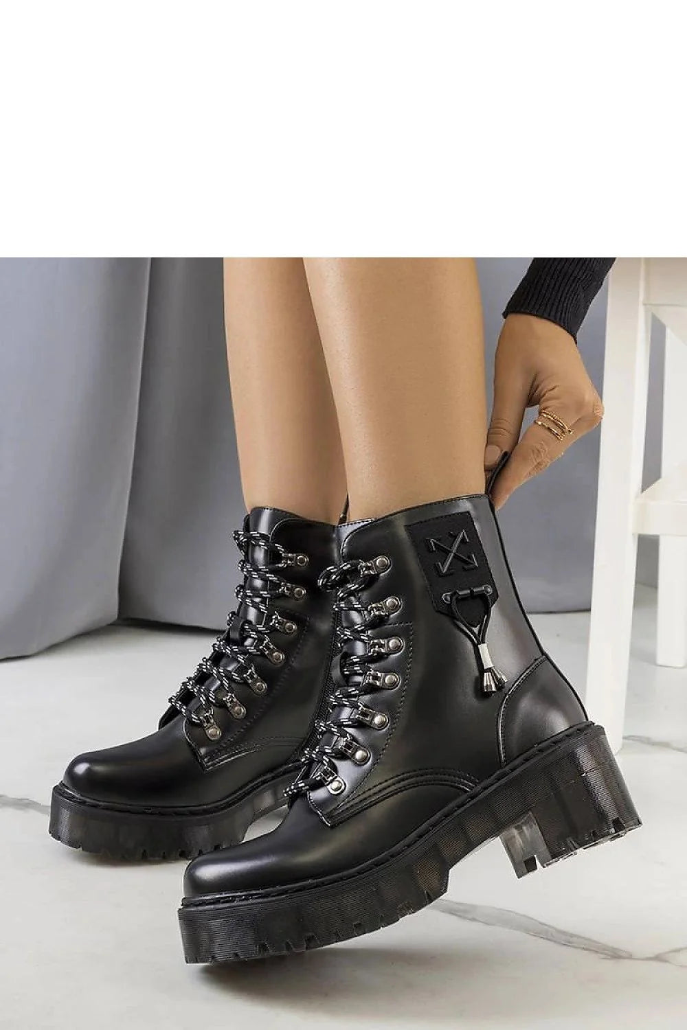 Bottes combat femme style audacieux cuir noir semelle épaisse lacets bicolores métalliques renfort cheville