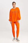 Ensemble sportswear pour femmes, sweatshirt orange, leggings, style casual, confort optimal, vêtement détente, mode moderne, porté quotidien, tenue relax, couleur vif, matière douce, maintien sécurisé, coupe ample, design graphique