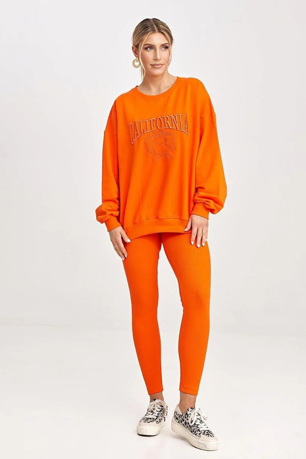 Ensemble sportswear pour femmes, sweatshirt orange, leggings, style casual, confort optimal, vêtement détente, mode moderne, porté quotidien, tenue relax, couleur vif, matière douce, maintien sécurisé, coupe ample, design graphique