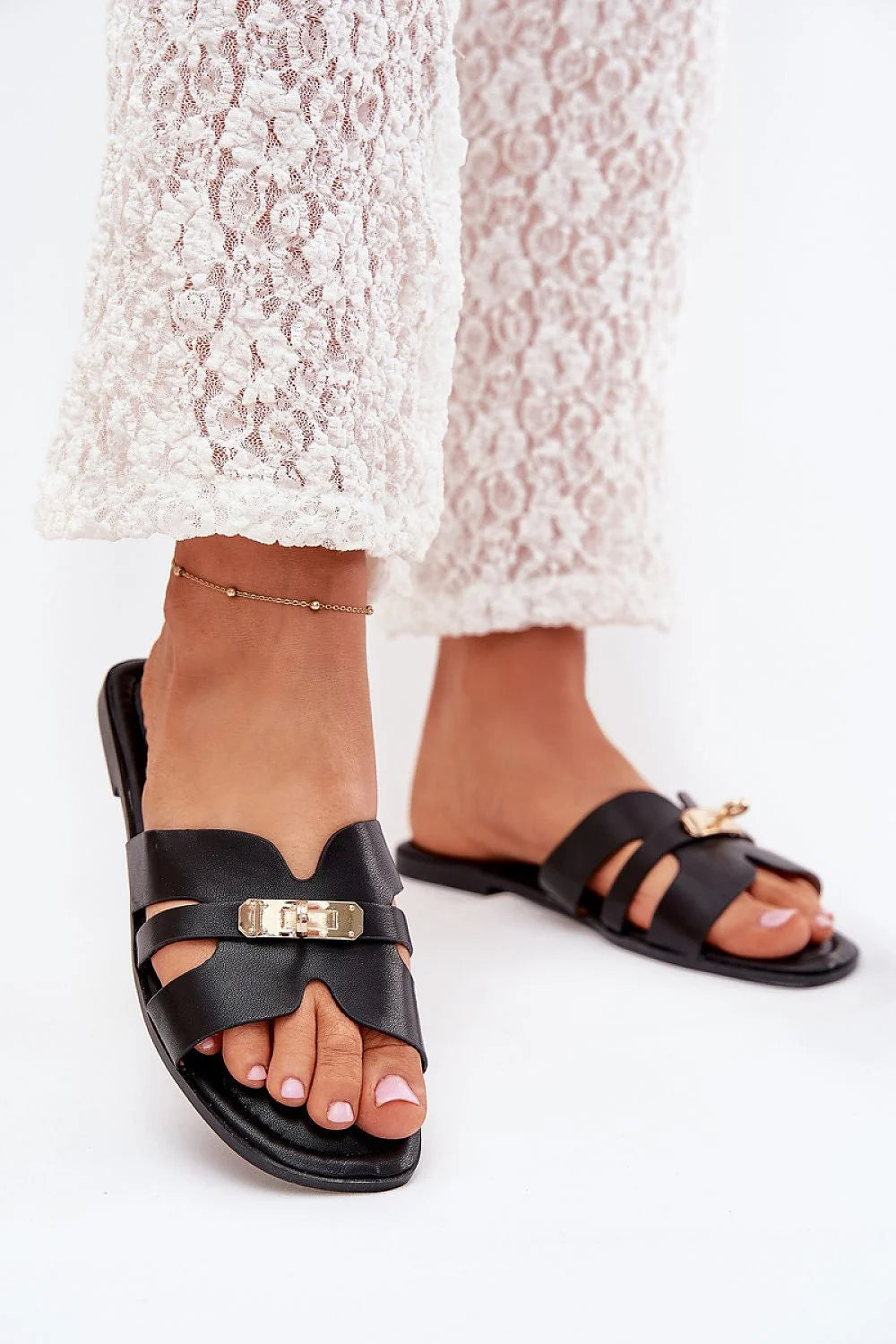 Sandales pour femmes élégantes en cuir noir style contemporain doré minimaliste plate semelle lanières croisées occasion estivale chic-casual
